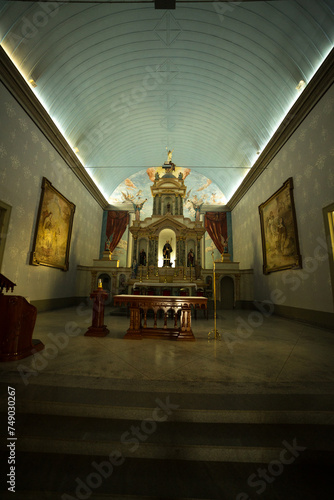 Interior de igreja católica, imagem de santos, altar e quadros na parede.  photo
