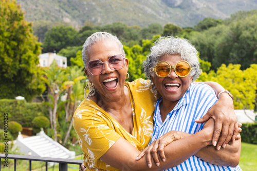 Senior African American woman and senior biracial woman share a joyful embrace outdoors photo