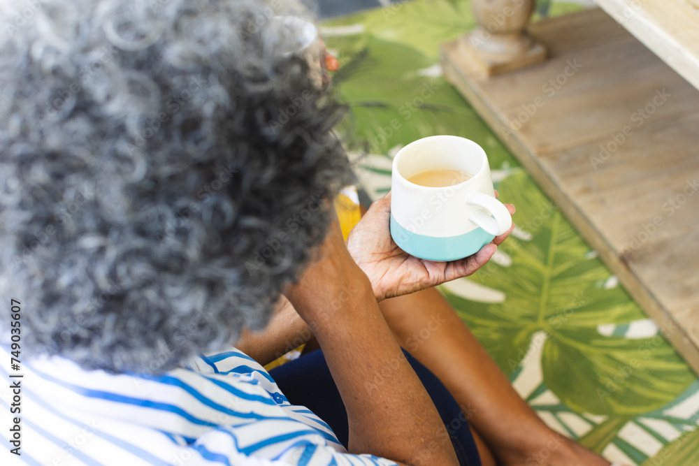 Senior African American woman with gray hair enjoys a cup of tea at home Senior African American woman with gray hair enjoys a cup of tea at home