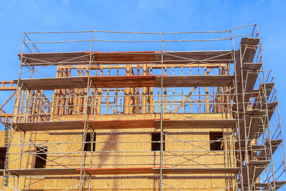 Building wooden framework with lumber scaffolding and blue sky Building wooden framework with lumber scaffolding and blue sky