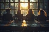 A serene backlit image of four people sitting together in contemplation during a sunset behind a window