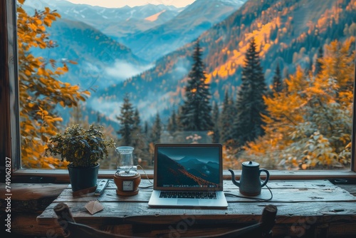 A comfortable workspace with a modern laptop set against the backdrop of a stunning autumn mountain vista photo