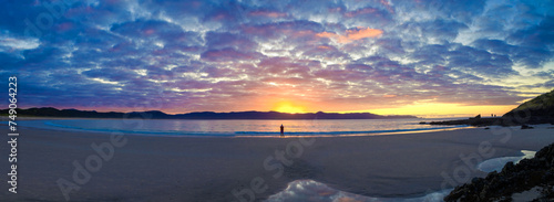 Lone figure on a beach with beautiful sunset, Spirits Bay, Northland, New Zealand photo
