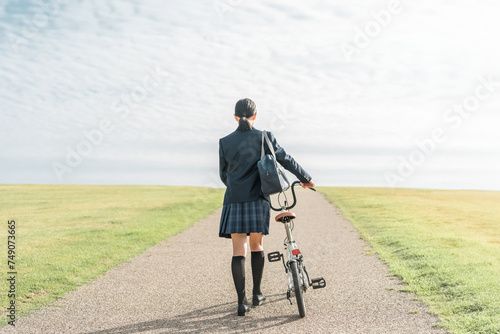 自転車で通学・登校・下校する制服姿の中学生・高校生（夢・希望・進路・道・将来・未来・青春・歩く） 