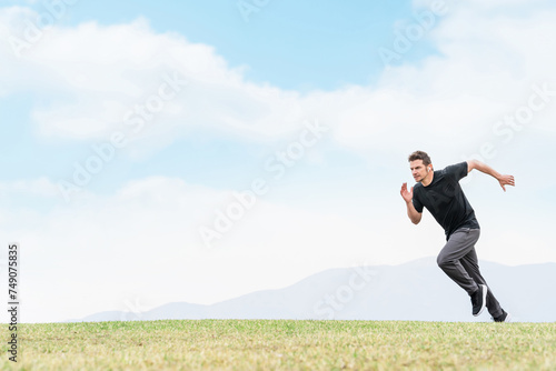 トレーニングのため公園でダッシュで走る練習をするスポーツウェアを着たアスリートの白人男性 