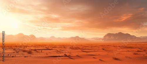 The desert landscape is spread out beneath the scorching sun, with mountains looming in the distance. Sand dunes create a rugged terrain as the mountains stand tall against the horizon.