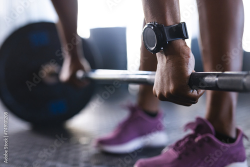 Close-up of a person's hands gripping a barbell, wearing a fitness watch photo