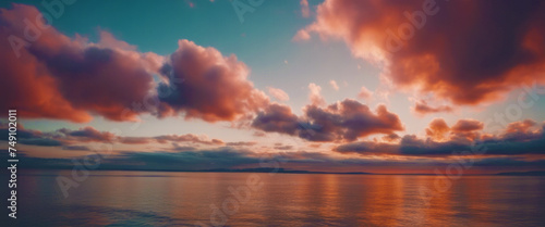 Serene sunset over the ocean, with the sky ablaze in warm hues and clouds reflecting the tranquil beauty of the moment.