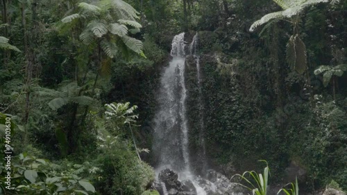 The unspoiled and beautiful Grenjengan Kembar waterfalls are located in the middle of the wilderness of Mount Merbabu National Park. Slow motion footage of dramatic waterfall with water splashes photo