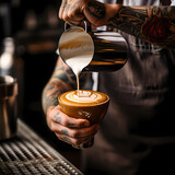 A close-up of a barista pouring latte art.