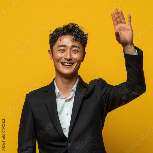 Handsome young man in business attire expressing himself by He raised his hand in a shy greeting as he smiled in celebration after a successful daytime business meeting.