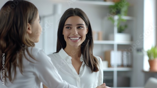 Smiling Australian woman in office, handshake, professional meeting, bright interior. © Archil