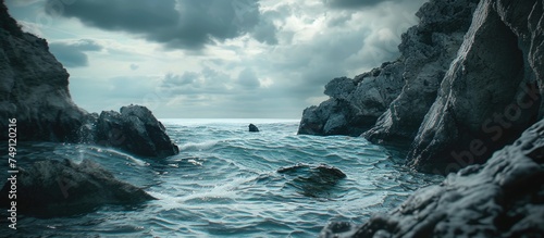 A dramatic scene unfolds as dark rocks jut out from the turbulent ocean water, creating a stark contrast in the composition. The waves crash against the sturdy rocks, sending sprays of water into the photo