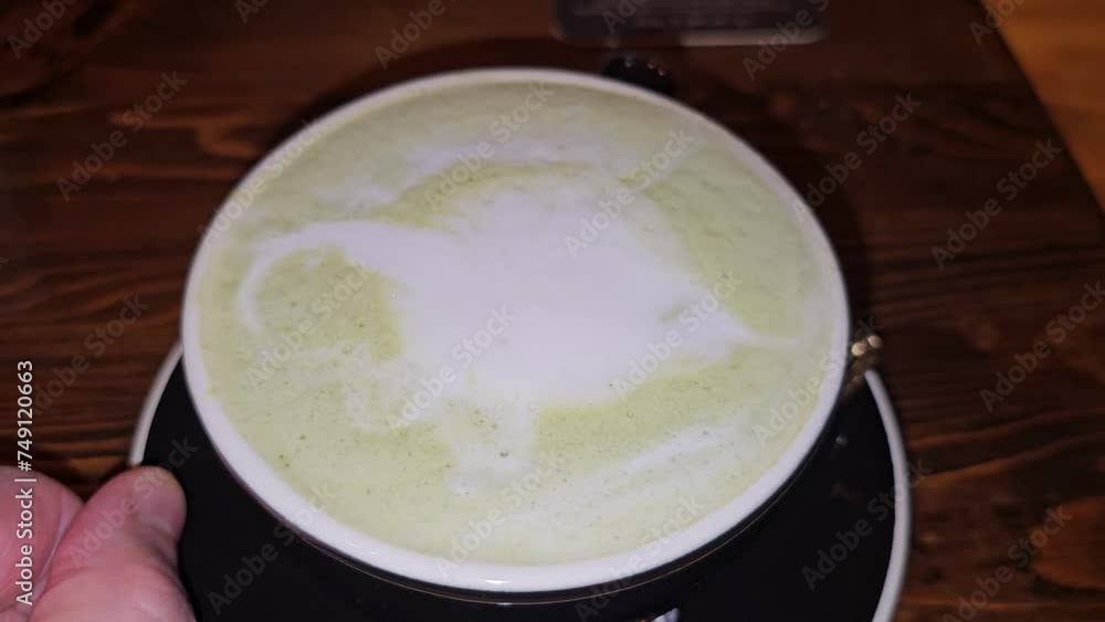 Foamy green tea matcha latte in cup on saucer Foamy green tea matcha latte in cup on saucer