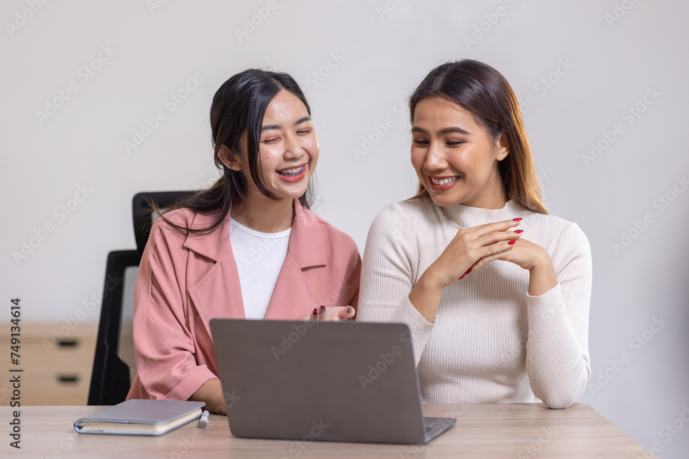 Two young asian happy business women working together for analyze planning and financial statistics and investment market in home office space Two young asian happy business women working together for analyze planning and financial statistics and investment market in home office space