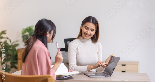 Two young asian happy business women working together for analyze planning and financial statistics and investment market in home office space