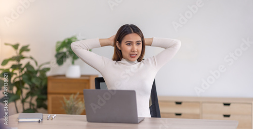 Beautiful young asian business woman working on her laptop in her home office.