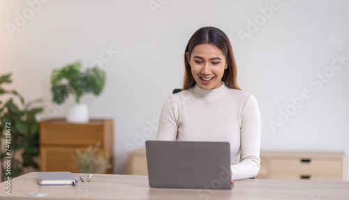 Beautiful young asian business woman working on her laptop in her home office. © David