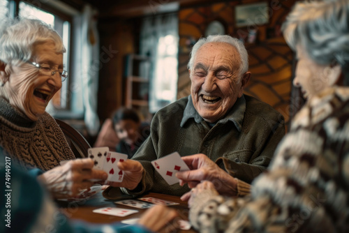 Group of happy senior people laughing while playing cards together at home