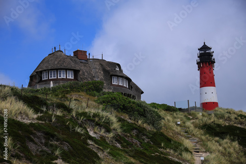 lighthouse and a typical sylt-style house on a sand dune
