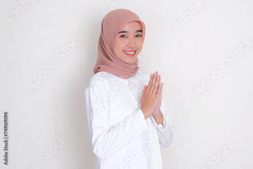 Moslem Asian woman smiling while doing greeting pose