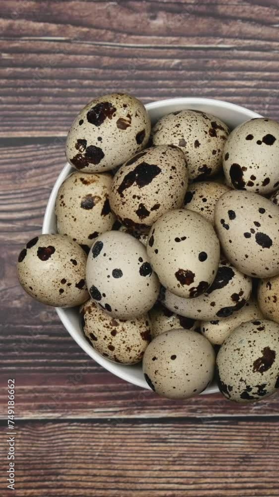 Rotating Quail Eggs On A White Plate On A Wooden Background. Top View. Vertical. Rotating Quail Eggs On A White Plate On A Wooden Background. Top View. Vertical.