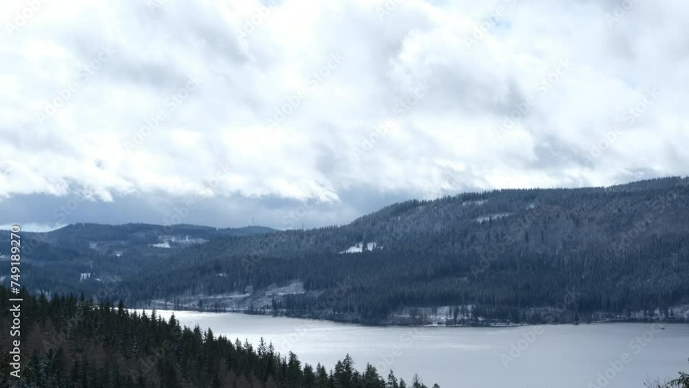 the winter lake between the mountains covered with snowy forest the winter lake between the mountains covered with snowy forest