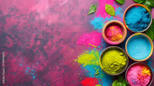 Vibrant colorful Gulal pigment powders in Indian traditional bowls at the right side on a pink background with copy space for text. Top view.