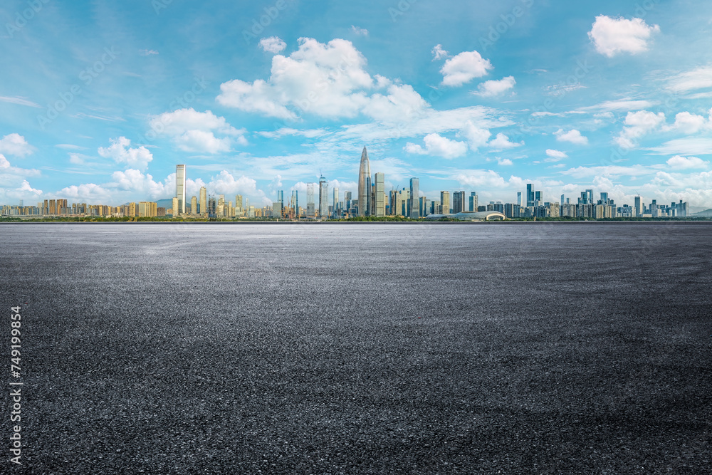 Empty asphalt road and modern commercial buildings skyline