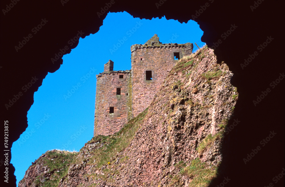 Dunnotar Castle view framed by a cave with blue sky - Stonehaven - Aberdeenshire - Scotland - UK