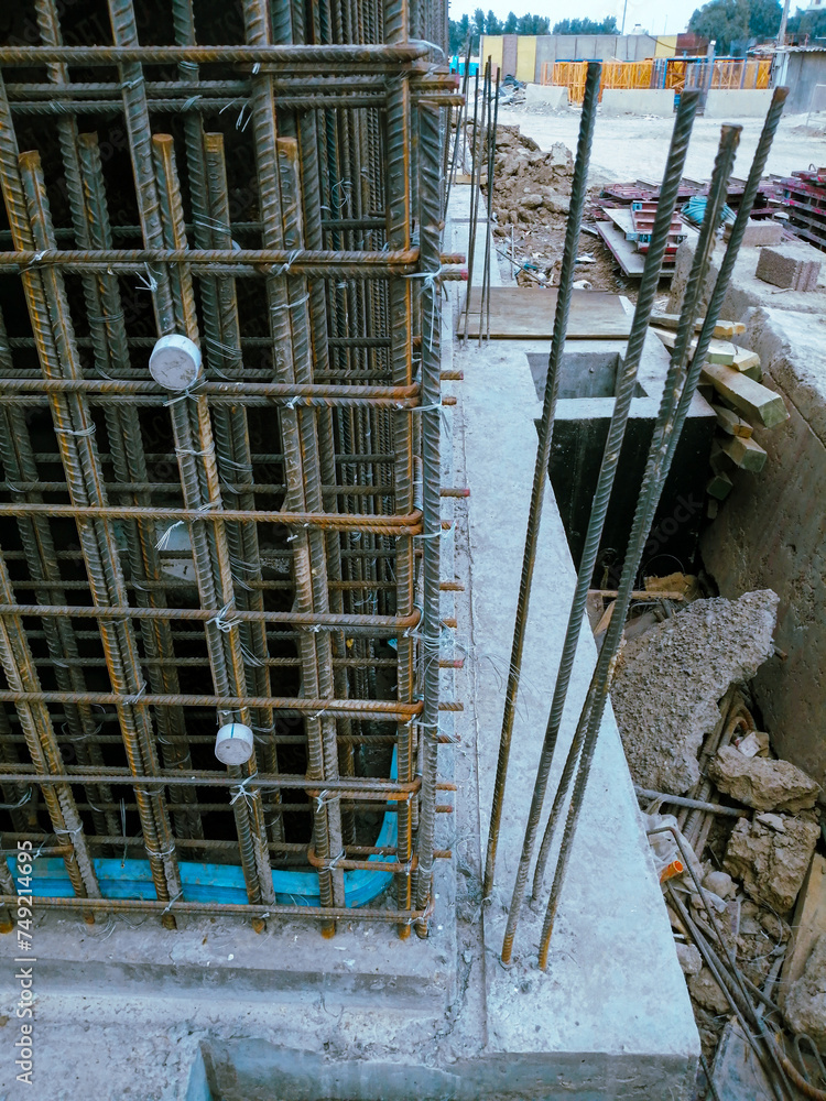 A corner of a building is being reinforced with metal bars. The bars are in a crisscross pattern and are covered in rust