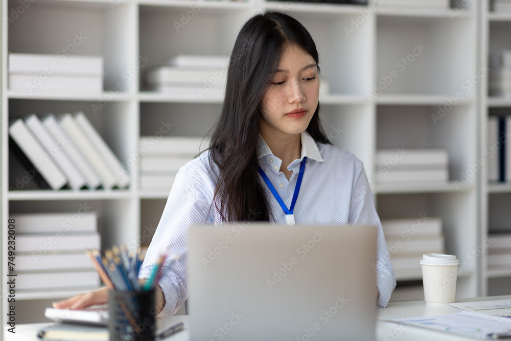 Serious businesswoman working with laptop and paperwork in office. Serious businesswoman working with laptop and paperwork in office.