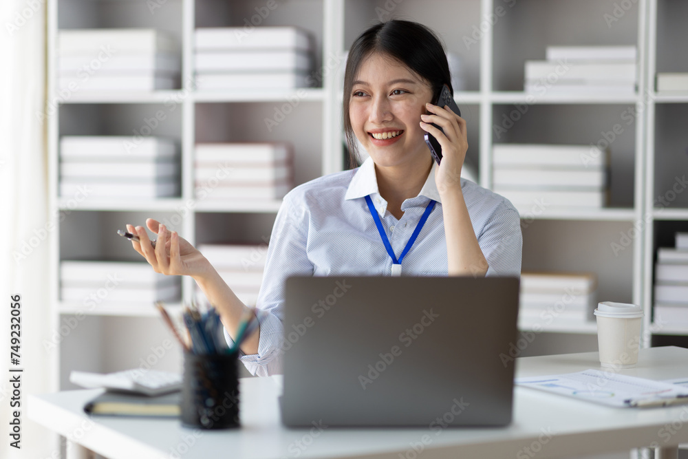 Businesswoman secretary in office using smartphone to send text messages online and talking with customers on phone. Businesswoman secretary in office using smartphone to send text messages online and talking with customers on phone.