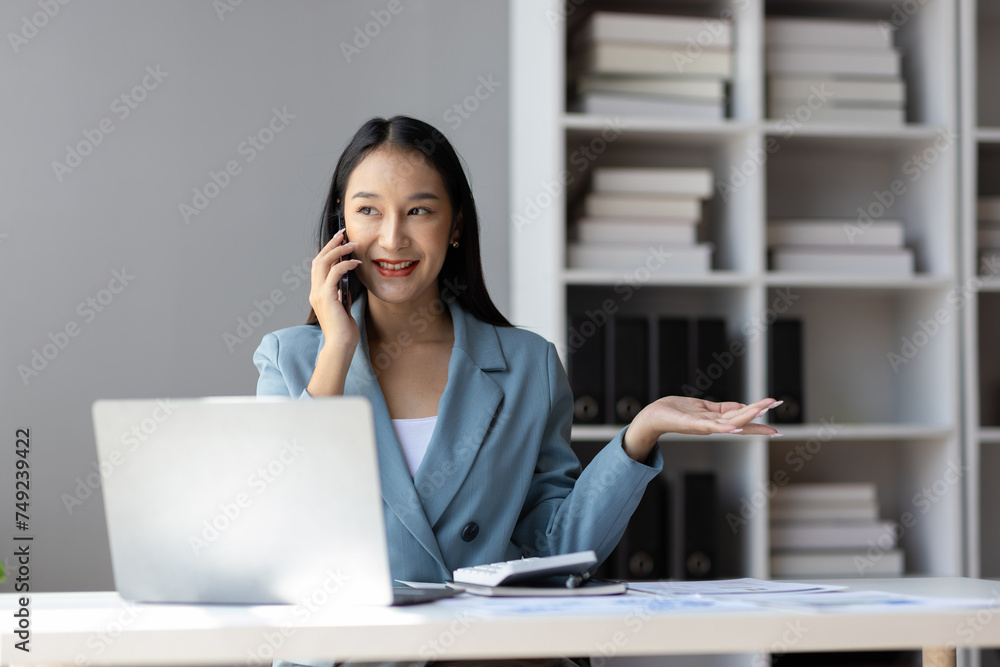 Businesswoman secretary in the office uses a mobile phone to send a message and is calling to talk with a customer. Businesswoman secretary in the office uses a mobile phone to send a message and is calling to talk with a customer.