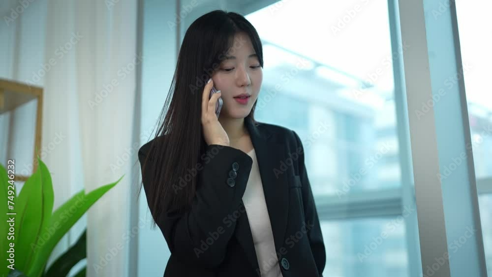 A woman multitasking: working while on a phone call. A woman multitasking: working while on a phone call.