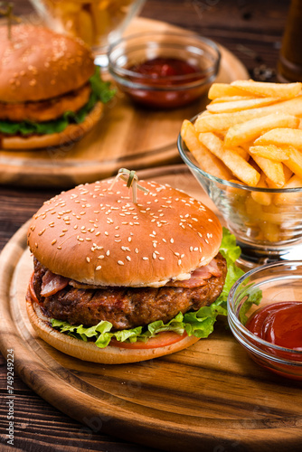 American cuisine burgers with beef, chicken, bacon, tomato and lettuce with french fries and ketchup.