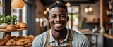Small business owner young black african man at entrance of cafe bakery smiling looking at camera from Generative AI