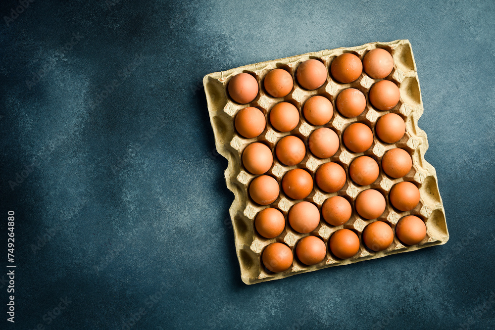 Top view, chicken eggs in a paper tray. On a gray concrete background. Top view, chicken eggs in a paper tray. On a gray concrete background.