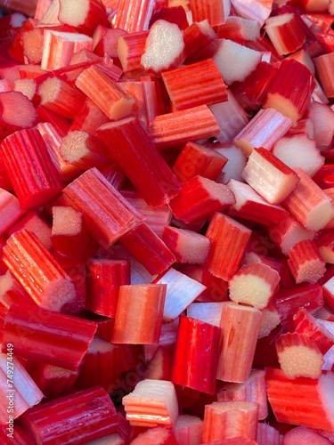 Rhubarb stems chopped red raw with cinnamon stick ready to cook background 