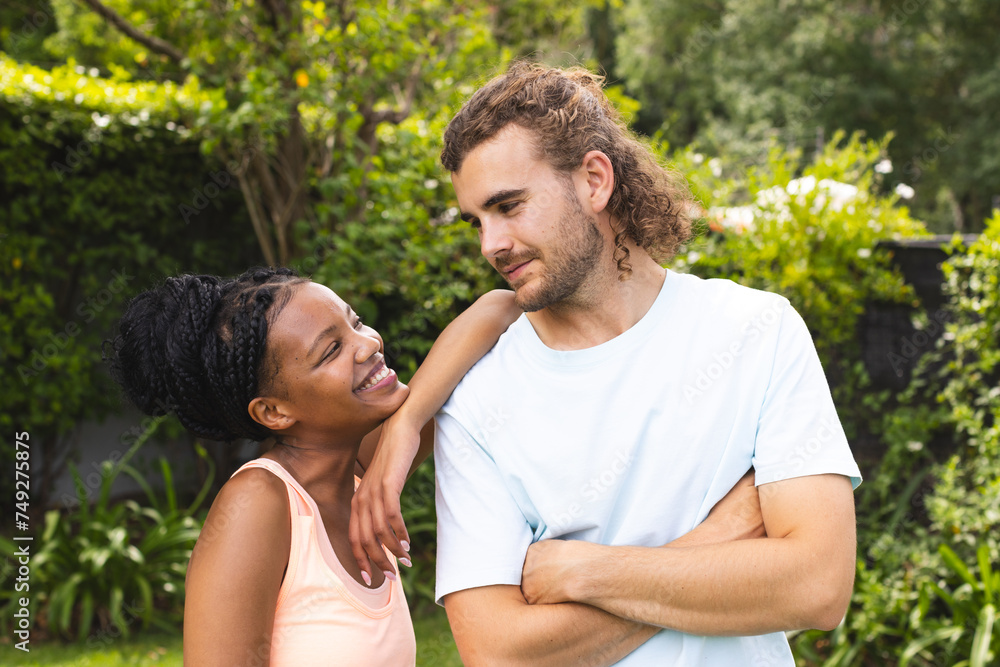 Diverse couple: young African American woman and Caucasian man share a joyful moment outdoors Diverse couple: young African American woman and Caucasian man share a joyful moment outdoors