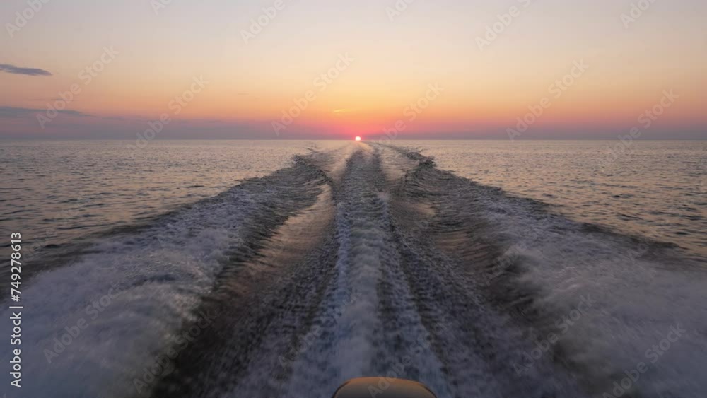 Motorboat speeds homeward at sunset, its wake cutting through calm waters of Ladoga Lake. Breathtaking view unfold as sun touches horizon, neat colored sky adds to tranquil and atmospheric scene. Motorboat speeds homeward at sunset, its wake cutting through calm waters of Ladoga Lake. Breathtaking view unfold as sun touches horizon, neat colored sky adds to tranquil and atmospheric scene.