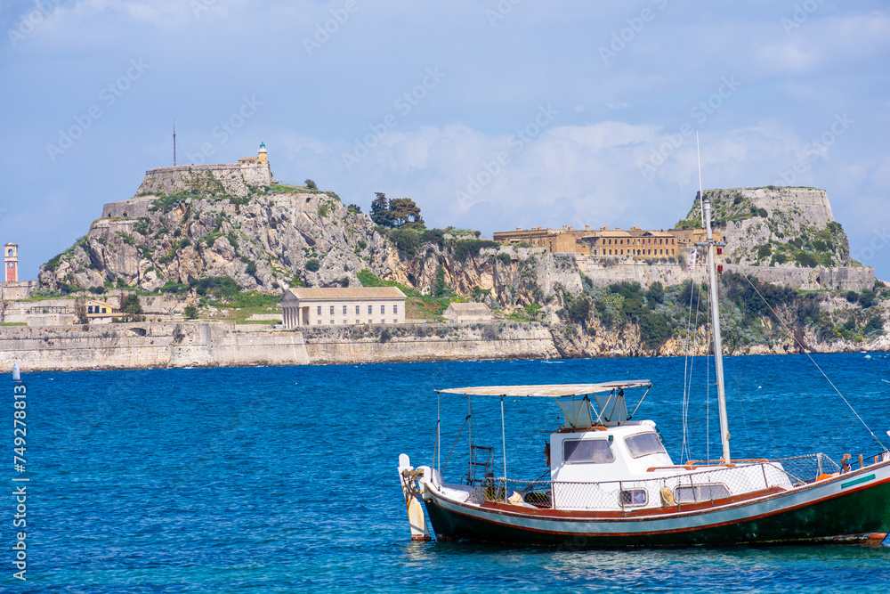 Corfu old fortress view from garitsa bay rith boat in front