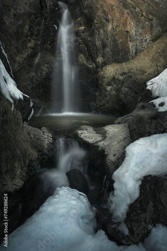 Mazobre waterfall in the Palencia mountain surrounded by snow on a winter day photo