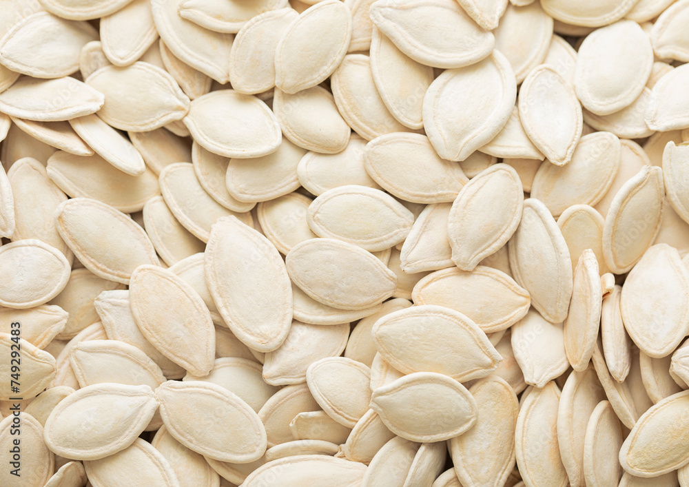 Raw white salted pumpkin seeds top view macro background.Healthy snack. Raw white salted pumpkin seeds top view macro background.Healthy snack.
