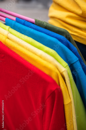 Cluster of colored plain t-shirts on hangers