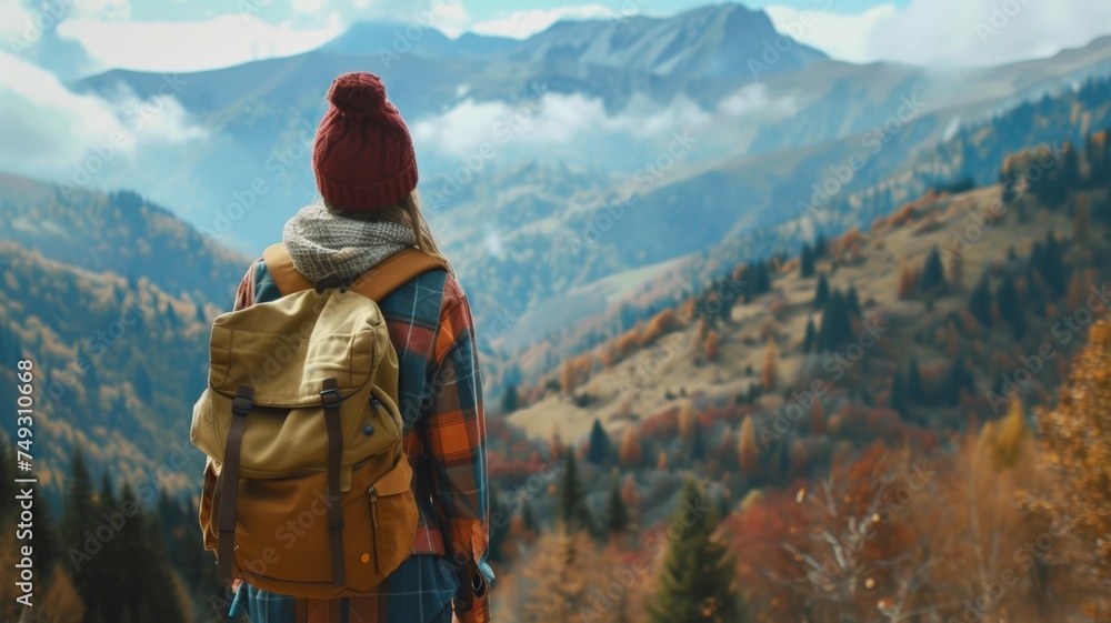 A beautiful woman with a backpack stands with her back turned and looking into the distance at the mountains. Inspiring travel lifestyle Autumn landscape. A beautiful woman with a backpack stands with her back turned and looking into the distance at the mountains. Inspiring travel lifestyle Autumn landscape.