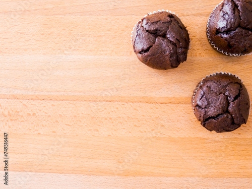 Top view of group of chocolate magdalenas, the typical spanish muffins over a wooden table. Copy Space