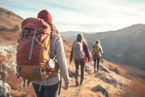 hipster with touristic rucksack walking on mountains path with friend in forward, spending weekend on fresh air for recreation in nature environment photo