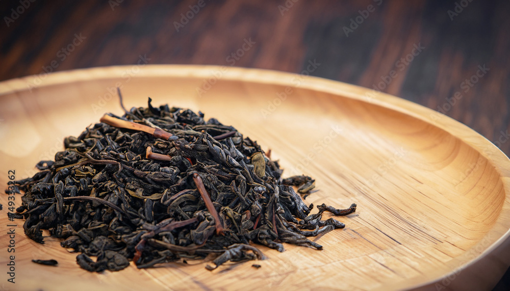Fototapeta premium close-up of dry Chinese tea in wooden bowl, vintage tone, selective focus