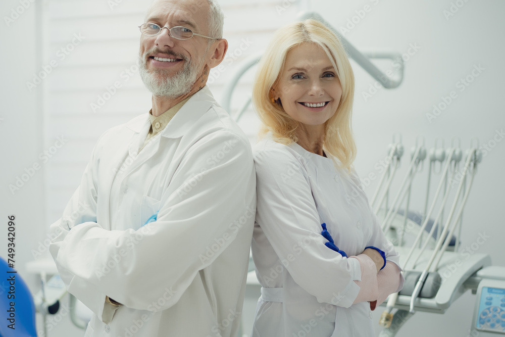 Male and female dental doctors wearing face sitting at his clinic. Male and female dental doctors wearing face sitting at his clinic.